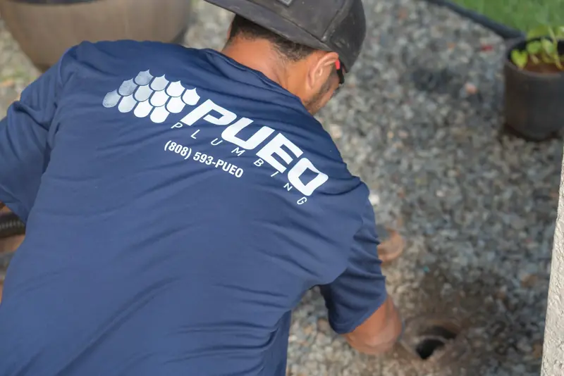 Pueo Plumbing technician working at a sewer cleanout in an Oahu yard