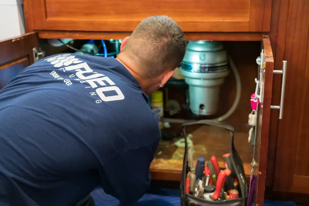 Pueo plumber repairing pipes under a kitchen sink Pueo plumber repairing pipes under a kitchen sink